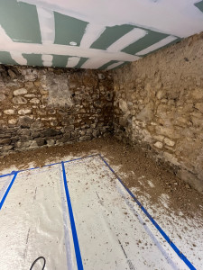 Photo de galerie - Préparation avant traitement à la chaux. Piquage des surfaces murales abîmées par l'humidité et les champignons de moisissure.