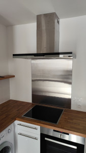 Photo de galerie - Fixation d'une hotte et de la plaque pour protéger le mur 