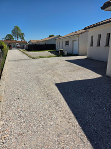 Photo de galerie - Réalisation d'un accès et d'un stationnement en béton concassé. Pose d'un caniveau à grilles raccordé au fossé pour assurer l'évacuation des eaux pluviales.