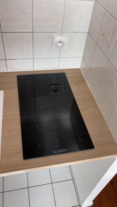 Photo de galerie - Installation, plaque de cuisson avec des coupes sur plan de travail et branchement