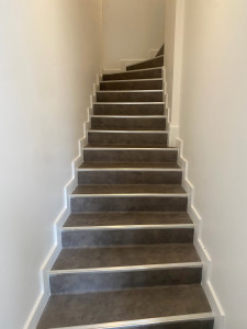 Photo de galerie - Réalisation d’une pose de lino sur escalier, avec découpes sur mesure et finitions soignées.