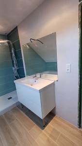 Photo de galerie - Réalisation d’une salle de bain moderne avec pose de carrelage mural grand format, faïence murale et finitions soignées autour du meuble vasque et de la douche. Un travail précis pour un rendu esthétique, durable et facile d’entretien