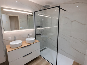 Photo de galerie - Rénovation complète de salle de bain : pose de carrelage mural et au sol, installation de la douche à l’italienne avec paroi vitrée, pose du meuble double vasque, robinetterie et finitions. Réalisation moderne, élégante et soignée.