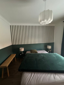 Photo de galerie - Chambre d'ami avec soubassement a peindre en vert,le restant en blanc et pose de papier peint sur le haut d'un mur 