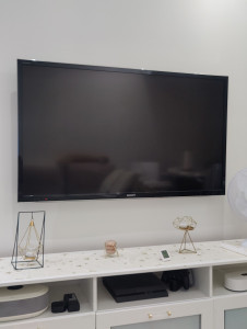 Photo de galerie - TV fixée au mur avec soin et précision – installation solide, alignée et câbles discrets pour un rendu impeccable.