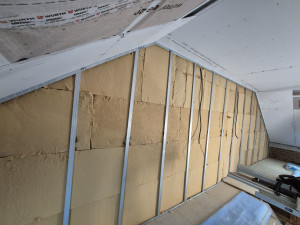 Photo de galerie - Mise en place d’une isolation intérieure sur ossature métallique avec panneaux isolants. Préparation soignée avant fermeture des parois pour garantir performance thermique et durabilité.