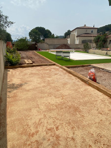 Photo de galerie - Remise à niveau du terrain , suivi d’une pose de traverse de chemin de fer traiter , du tout venant à étais posé et damé et pose de synthétique + crémation du terrain de boule 