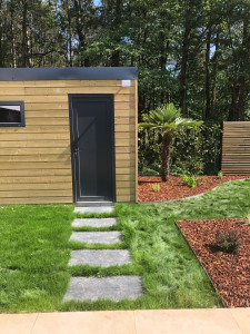 Photo de galerie - Cabanon en bois de bardage/ pas japonais en chyste/ gazon de placage/bordure alu/ plantation d’arbuste et paillage