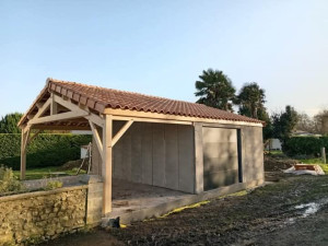 Photo de galerie - Montage d'un garage en préfabriqué béton et d'un auvent bois. 