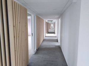 Photo de galerie - Le mur présente une peinture blanche uniforme et propre, avec une finition soignée et professionnelle qui donne au couloir un aspect moderne et lumineux. Les angles et les bords sont réalisés avec précision, sans défauts visibles.