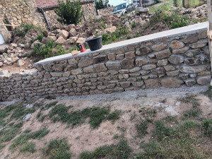 Photo de galerie - Première partie du mur de la 2 ème photo 
ces un mur en escalier avec pierre d’angle 
dessus il y a une arase fait au ciment 
