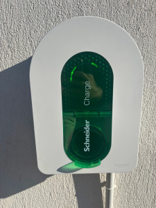 Photo de galerie - Installation d’une borne de recharge Schneider pour véhicule électrique, fixée au mur et mise en service.