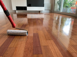 Photo de galerie - Vitrification de parquet : application de la finition au rouleau.