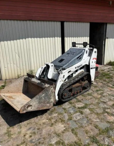 Photo de galerie - Mini-chargeur sur chenille avec divers équipements (godet, godet grappin, tarière ou préparateur de sol)