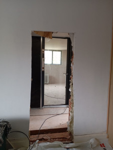 Photo de galerie - Préparation de l'ouverture de porte caché pour l'accès à l'extension en ossature bois 
