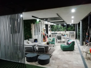Photo de galerie - Réalisation d'une cuisine d'été en béton ciré , pose de travertin et décoration 