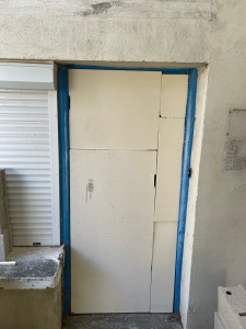 Photo de galerie - Pose isolant entre la porte et le mur 