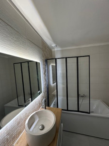 Photo de galerie - Mis en place d'une baignoire avec sa paroi de douche.