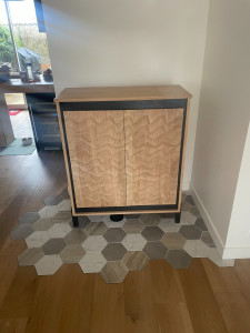 Photo de galerie - Buffet moderne en bois clair avec un joli veinage ondulé, encadré de noir et posé sur des pieds fins. Un meuble élégant et chaleureux qui attire le regard