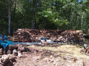 Photo de galerie - Fendage, éventuellement tronçonnage, et rangement de bois, avec certaines palettes bien recalées sur des parpaings 