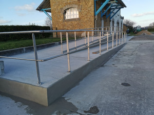 Photo de galerie - Réalisation d’un chemin d’accès pour Personnes à Mobilité Réduite (PMR) en béton balayé , comprenant la mise en œuvre d’une rampe conforme aux normes d’accessibilité.