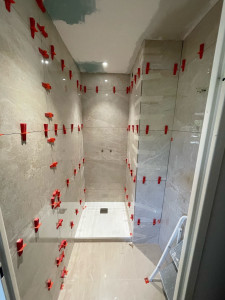 Photo de galerie - Pose de carrelage sol et mur d’une salle de bain avec pose de bac à douche meuble vasque suspendu et plomberie 