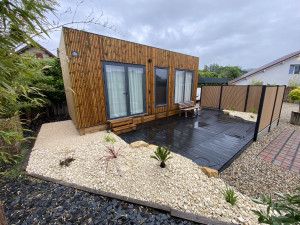 Photo de galerie - Pose de clôture bardline brun clair et noir, pose dune terrasse composite. Aménagement massifs minérales et végétales 