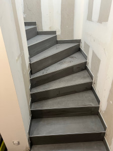 Photo de galerie - Escalier carrelé en rénovation, avec pose de carrelage sur les marches et contremarches.