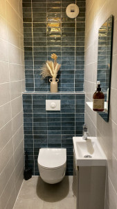 Photo de galerie - Travaux de carrelage dans une salle de bain en rénovation. Pose de carrelage mural avec finitions soignées et préparation des surfaces avant la phase finale.