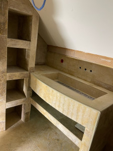 Photo de galerie - Fabrication de meubles vasque avec colle et tablettes revêtue d’un parement en travertin 