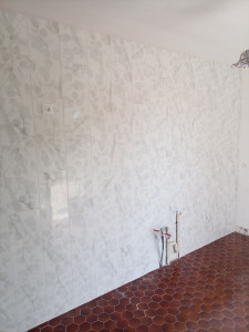 Photo de galerie - Pose de carrelage 60x25 à la verticale et en décalé, sur un mur de cuisine. 

