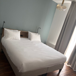 Photo de galerie -     double soigneusement préparé avec des draps blancs impeccables et quatre oreillers.