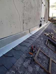 Photo de galerie - Remplacement d’un faîtage en lignolet en ardoise naturelle.
Façonnage et pose d’un solin en zinc naturel.