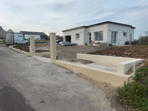 Photo de galerie - Réalisation du terrassement, maçonnerie (seuil portail, caniveaux, piliers de portail et muret)et d'un enduit gratté ton pierre clair.