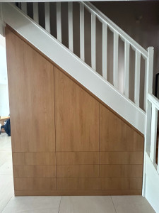 Photo de galerie - Création d’un rangement sous escalier sur mesure, avec façades en bois et optimisation de l’espace