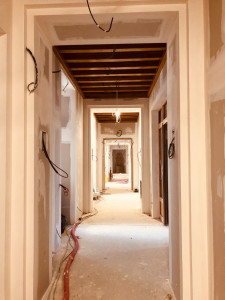 Photo de galerie - Réalisation des travaux de plâtrerie dans le couloir d'un hôtel : pose de plaques de plâtre, bandes à joints, ratissage et préparation des supports avant peinture. Un travail soigné sur un chantier professionnel
