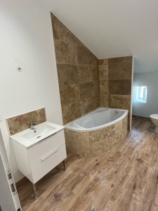 Photo de galerie - Réalisation de la faïence en travertin 40x60 et du tablier de la baignoire en cyporex puis carrelage travertin 5x5 