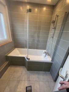 Photo de galerie - Pose d’une baignoire avec paroi de douche et robinetterie ainsi que raccord faïence