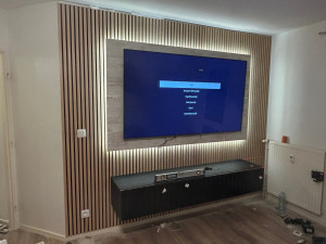 Photo de galerie - Panneau mural à volants et meuble TV suspendu créé en renforçant les supports muraux mesurés à des hauteurs fixes pour atteindre un produit fini