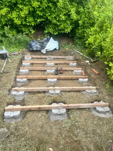 Photo de galerie - J’ai réalisé la mise en place d’une structure en bois posée sur des plots en béton, en veillant à l’alignement et au niveau pour assurer une base solide.