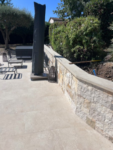Photo de galerie - Création d’un mur en agglos, avec habillage en pierre et pose de dalles de finition sur le dessus. Travail réalisé avec soin, de la maçonnerie jusqu’aux finitions.