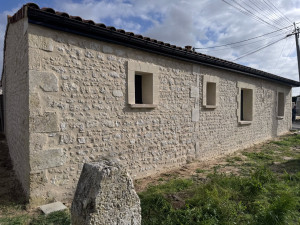 Photo de galerie - Enduit d'une maison joint de moellon décoration autour des ouverture en fausse pierre en enduit et finition gratter et imitation moellon sur une partie de la maison. 
