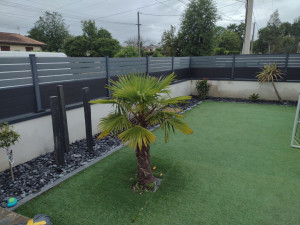 Photo de galerie - Création d'une bordure tout autour du terrain de jeu des enfants avec plantation d'arbres qui ne nécessite pas d'arrosage. 