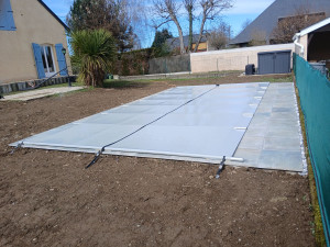 Photo de galerie - Margelle , carreaux coller , cailloux contre le mur et pose de bache a barre 