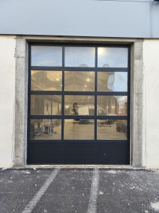Photo de galerie - Pose porte sectionnelle industrielle panneau vitré. 
