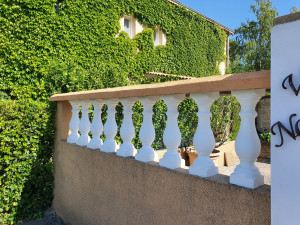 Photo de galerie - Muret avec balustres blancs et chaperon en pierre ton sable, alliant élégance et finition soignée pour une clôture esthétique et durable.

