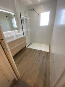 Photo de galerie - Salle de bain complète - carrelage imitation parquet, faïence effet vague + niche dans la douche.