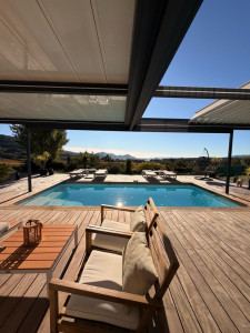 Photo de galerie - Intervention d’entretien et de nettoyage complet d’une terrasse extérieure située dans un environnement résidentiel haut de gamme, avec vue dégagée sur piscine et panorama maritime.