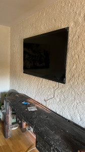 Photo de galerie - Installation de support de télévision sur un mur massif.