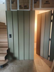 Photo de galerie - Cloison en MDF et tasseaux pin dissimulant une porte d'accès à des sanitaires ainsi qu'un placard de rangement.